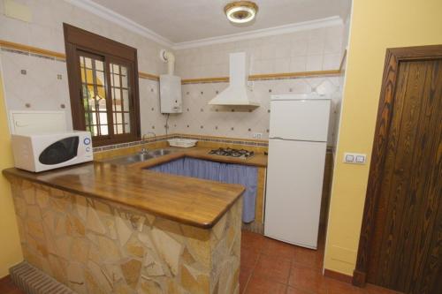 a kitchen with a counter and a white refrigerator at Casas el Albarracín in El Bosque
