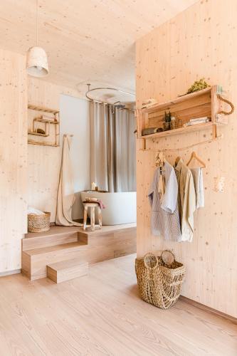 a room with a wooden wall with a shelf and towels at The Nest by Cooking and Nature in Alvados