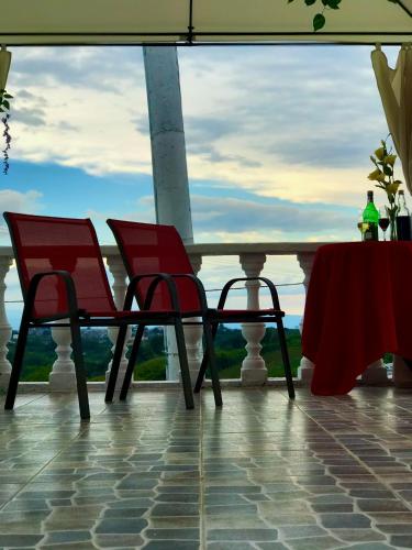 two chairs and a table with a view of the ocean at Castillo Del Toro in Armenia