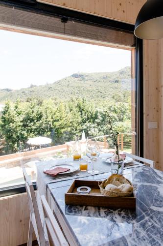 Una mesa con una bandeja de copas de vino y una ventana. en The Nest by Cooking and Nature, en Alvados