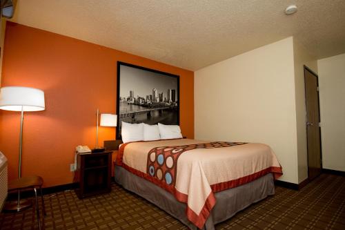 a hotel room with a bed and a picture on the wall at Super 8 by Wyndham Altoona in Altoona