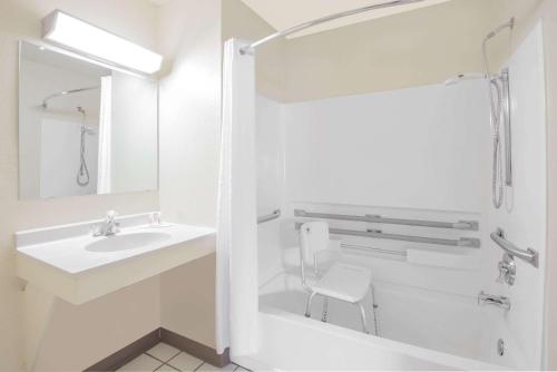a white bathroom with a sink and a mirror at Super 8 by Wyndham Altoona in Altoona