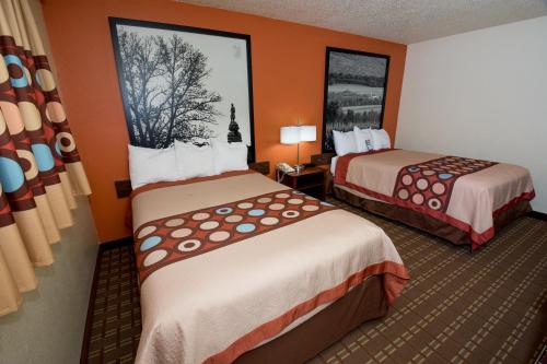 a hotel room with two beds and orange walls at Super 8 by Wyndham Altoona in Altoona