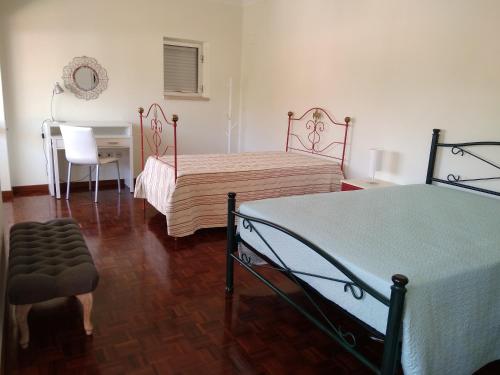 a bedroom with two beds and a desk and a table at O Terraço da Ribeira in Sertã