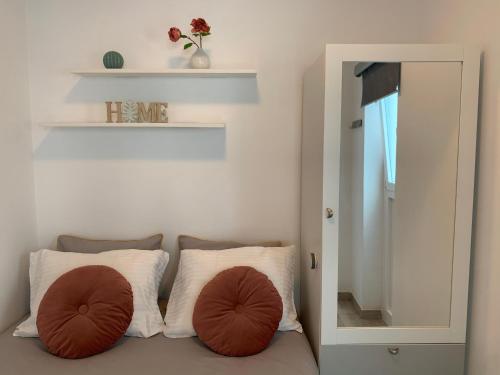 - une chambre avec un lit avec deux oreillers et un miroir dans l'établissement Cómodo apartamento en el corazón dé Tenerife, à La Laguna