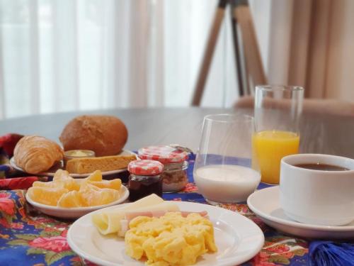 ein Tisch mit Tellern mit Frühstücksspeisen und Orangensaft in der Unterkunft VIVA Size Flats Clérigos in Porto