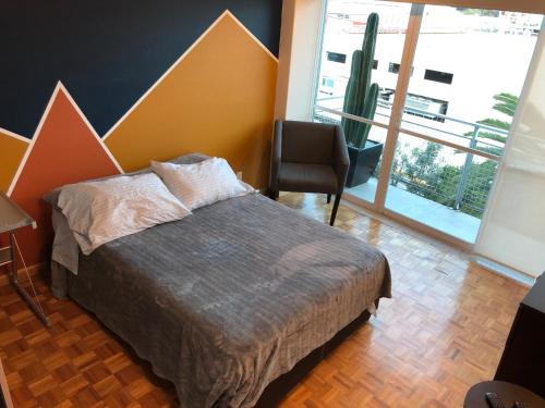 a bedroom with a bed and a chair and a cactus at Caravansaro Vazquez de Mella 347 Polanco in Mexico City