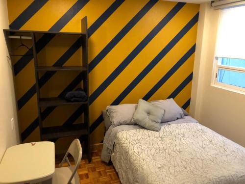 a bedroom with a yellow and blue striped wall at Caravansaro Vazquez de Mella 347 Polanco in Mexico City