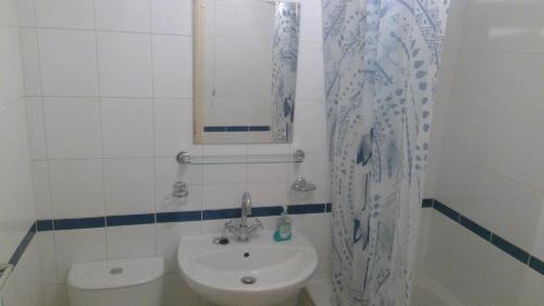 a bathroom with a sink and a toilet and a mirror at Cosy house for business travel and pleasure in Bickershaw