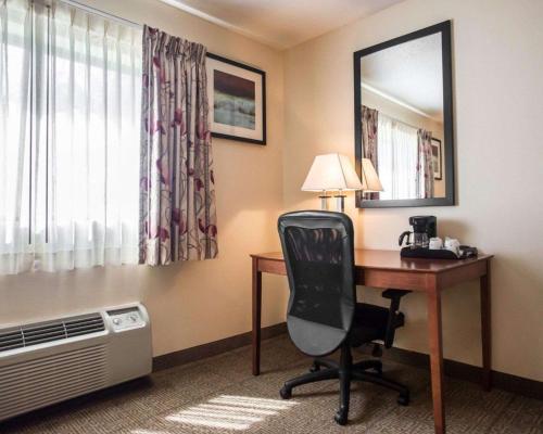 a hotel room with a desk with a chair and a mirror at Quality Inn New Columbia-Lewisburg in New Columbia