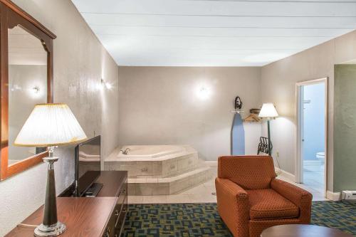 a living room with a chair and a bath tub at Econo Lodge Cranston - Providence in Cranston