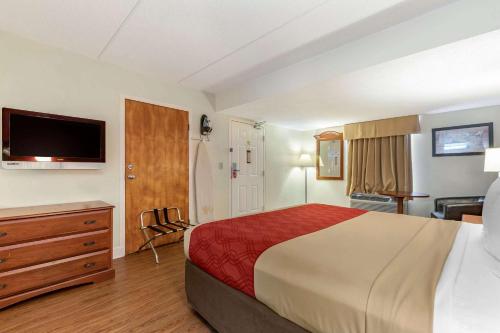 a hotel room with a bed and a flat screen tv at Econo Lodge Inn & Suites in Lugoff