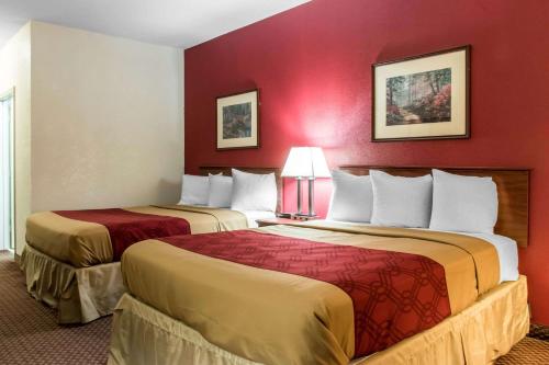 two beds in a hotel room with red walls at Econo Lodge Carlisle Central in Carlisle