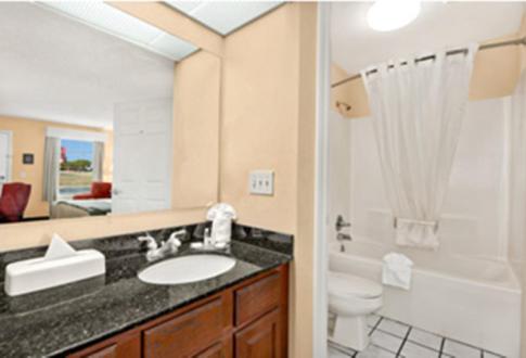 a bathroom with a sink and a toilet and a shower at Baymont by Wyndham Waycross in Waycross