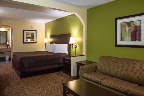 a hotel room with a bed and a couch at Rodeway Inn & Suites in Clarksville