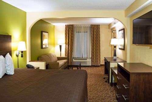 a hotel room with a bed and a couch at Rodeway Inn & Suites in Clarksville