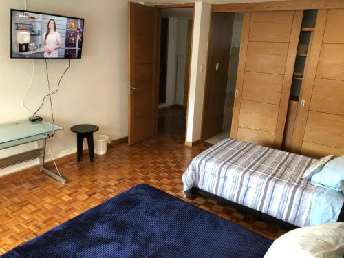 a bedroom with a bed and a tv on the wall at Caravansaro Vazquez de Mella 347 Polanco in Mexico City