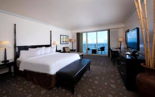 a hotel room with a large bed and a television at Atlantic Luxury Boutique Hotel & Spa in Fort Lauderdale