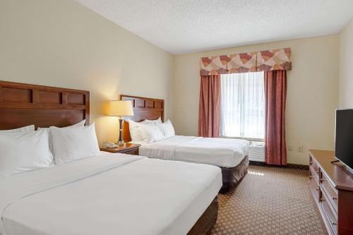 a hotel room with two beds and a television at Quality Suites in San Antonio