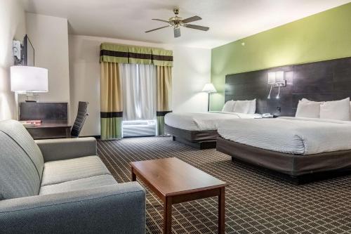 ein Hotelzimmer mit 2 Betten und einem Sofa in der Unterkunft Clarion Inn & Suites Weatherford South in Weatherford