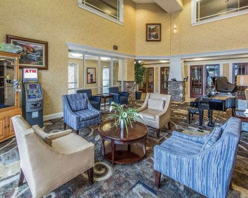 a living room with couches and chairs and a piano at Clarion Inn Near Island Drive in Pigeon Forge