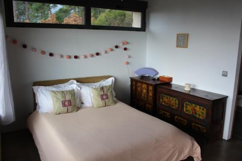 a bedroom with a bed with pillows and a window at Hotel La Canela in Piedralaves