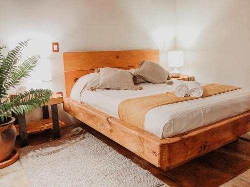a bedroom with a wooden bed with towels on it at Hotel Valle Místico in Tepoztlán