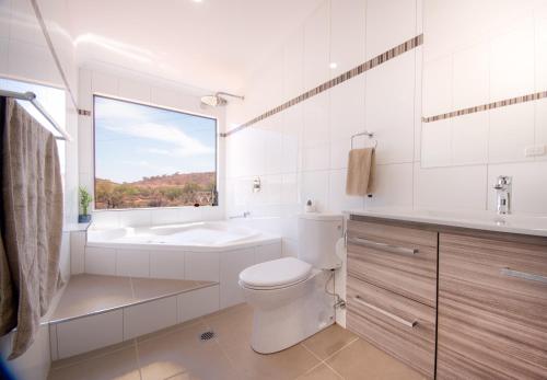 
a bathroom with a sink, toilet, and mirror at Broken Hill Outback Resort in Broken Hill
