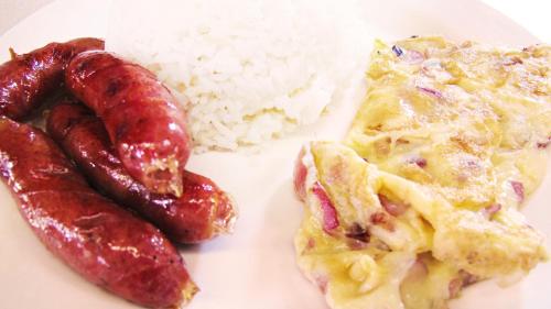 a plate of food with eggs sausage and rice at CounTess Pension House in Liloan
