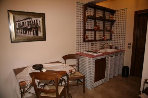 a kitchen with a table and a table and chairs at Roes Suites in Kato Loutraki
