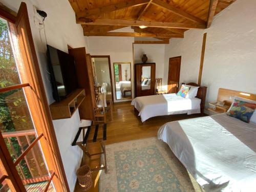 a bedroom with two beds and a television in a room at Terrazas de Salento in Salento