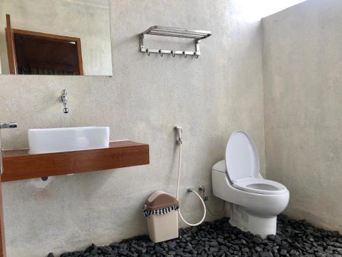 a bathroom with a toilet and a sink at Pondok Senaru Cottages in Senaru