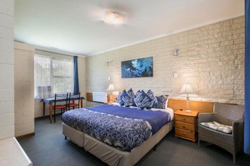 1 dormitorio con 1 cama, 1 mesa y 1 silla en Allamar Motel en Mount Beauty