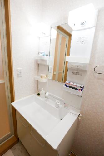 a bathroom with a white sink and a mirror at Tokyo Enjoy Hotel in Tokyo