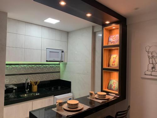 a kitchen with a counter with dishes on it at Presidential Suite na orla da Praia da Costa in Vila Velha