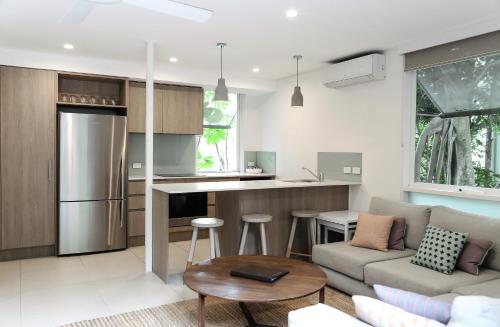 a living room filled with furniture and a kitchen at The Hastings Beach Houses in Noosa Heads