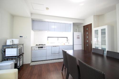 a kitchen with a table and a kitchen with white appliances at Atrium Deluxe Apartments Osaka - Self Check-In Only in Osaka