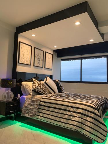 a bedroom with a large bed with a large window at Presidential Suite na orla da Praia da Costa in Vila Velha