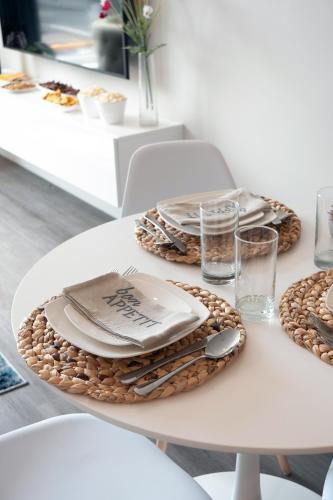 a white table with plates and napkins on it at Luxury Furnished Apartments by Hyatus Downtown at Yale in New Haven