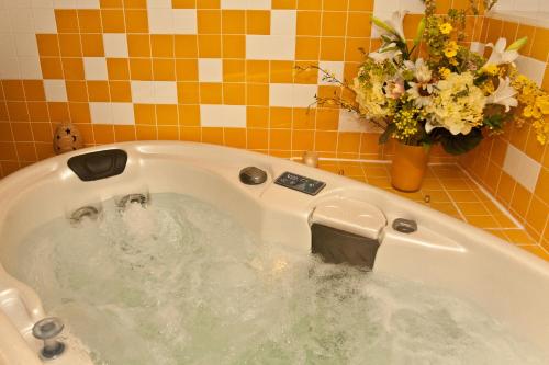 a bath tub filled with water with flowers in it at Hotel Rural Quinta da Geia in Aldeia das Dez