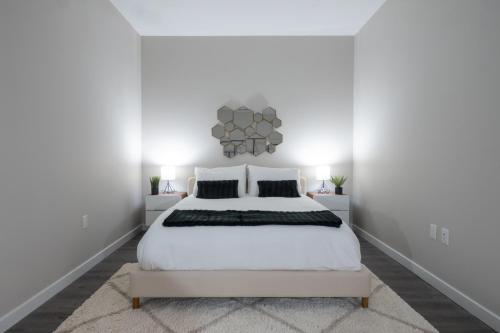 a white bedroom with a white bed and white walls at Luxury Furnished Apartments by Hyatus Downtown at Yale in New Haven