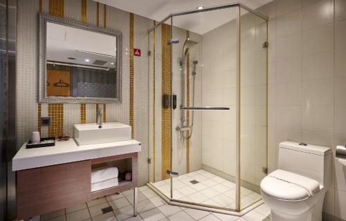 a bathroom with a shower and a toilet and a sink at Oursea Hotel in Wuqi