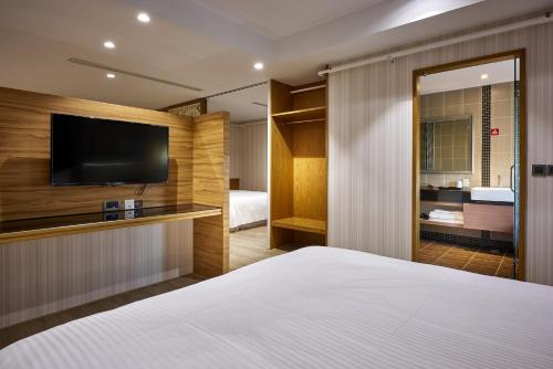 a bedroom with a bed and a flat screen tv at Oursea Hotel in Wuqi