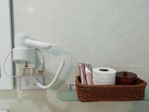 a bathroom counter with a basket of toilet paper and a phone at Morinaka Craftfe & Poshtel in Ban Na Muang
