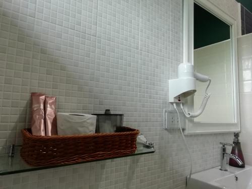 a bathroom with a basket on a shelf next to a sink at Morinaka Craftfe & Poshtel in Ban Na Muang