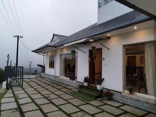 a white house with a patio in front of it at Vagamon Hill Chimes in Vagamon