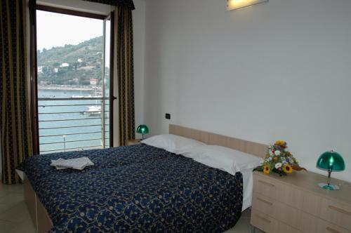 una camera da letto con un letto e una grande finestra di Hotel Residence Le Terrazze a Portovenere
