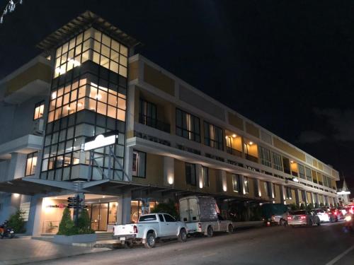 a white truck parked in front of a building at night at Sriracha Orchid Hotel in Si Racha
