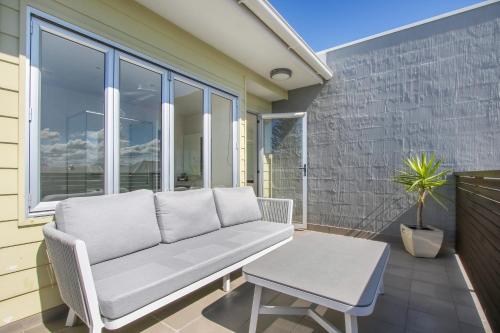 a white couch on a patio with a table at 5 Knots Metung in Metung