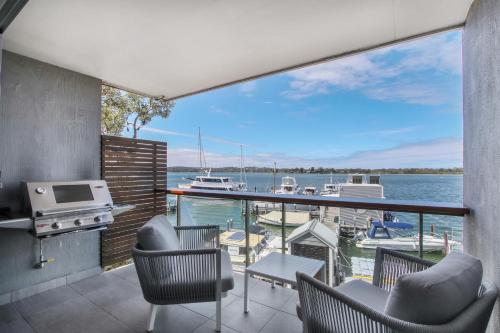 a balcony with chairs and a view of a marina at 5 Knots Metung in Metung
